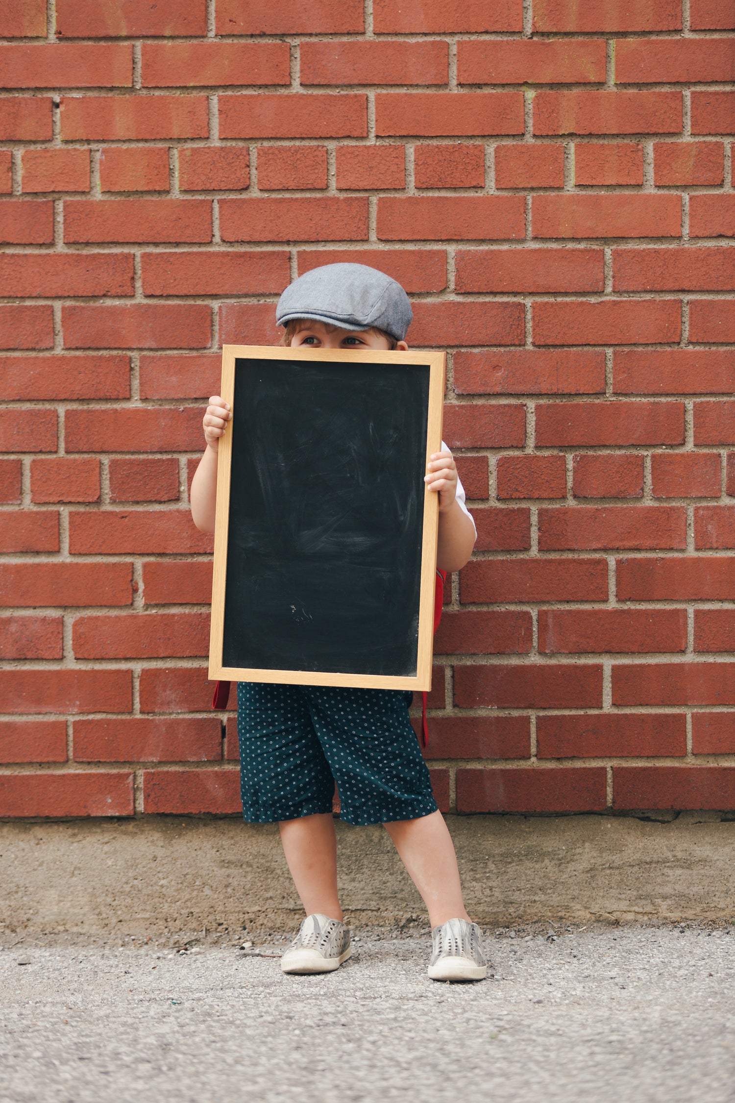 Little boy holding blank chalkboard